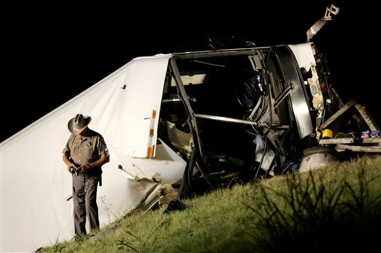 In this Aug. 8, 2008, photo, A Texas state trooper makes photographs at a bus accident scene on U.S. 75 North bound that killed several people in Sherman, Texas. 